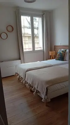 a bedroom with two beds and a window at La Collégiale in LʼIsle-sur-la-Sorgue
