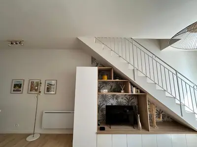 a living room with a staircase and a tv at La Collégiale in LʼIsle-sur-la-Sorgue