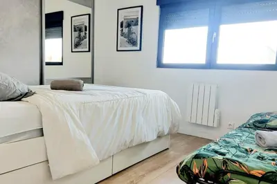 a white bedroom with a bed and two windows at 