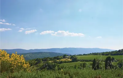 a view of a green field with mountains in the background at Amazing Home In Sainte Croix-À-Lauze in Sainte-Croix-à-Lauze