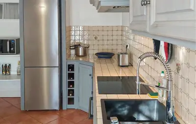 a small kitchen with a stainless steel refrigerator at Amazing Home In St Martin De Castillon in Saint-Martin-de-Castillon