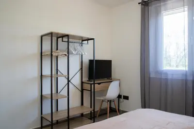 a bedroom with a book shelf and a television at L Orchidée in Mormoiron