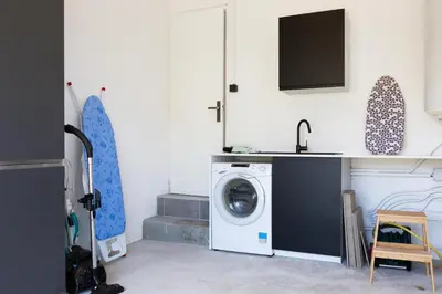 a laundry room with a washing machine and a sink at L Orchidée in Mormoiron