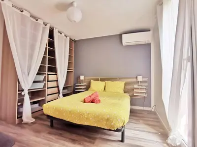 a bedroom with a yellow bed with yellow sheets at Les quatre loges - joli t2 jardinet et parking *3 in Aix-en-Provence