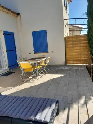 a patio with a table and chairs and blue doors at Sud luberon in Ansouis