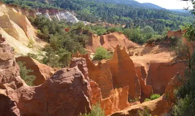 a view of a canyon with rocks and trees at Sud luberon in Ansouis