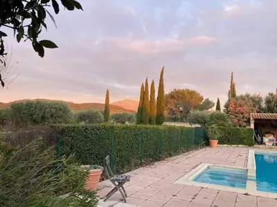 a swimming pool in a garden with a fence and trees at Gîte au milieux des oliviers. in Caromb