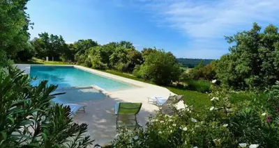 a swimming pool with chairs in a garden at Appart Hôtel - Nature et Spa in Aurons