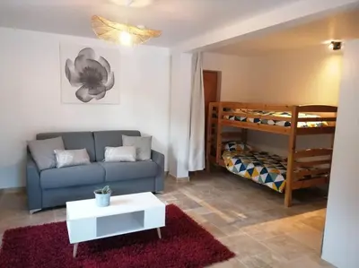 a living room with a couch and a bunk bed at Joli studio calme et moderne in Pertuis