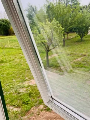 a window with a view of a field with trees at Cabane la Clef des Champs au Mas des Entrages in Salon-de-Provence