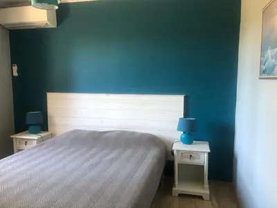 a bedroom with a bed and two tables with lamps at VILLA AVEC PISCINE in Roussillon