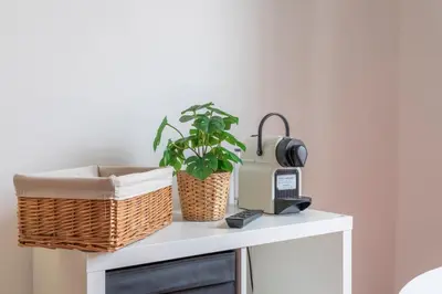 a white cabinet with two baskets and a plant on it at Studio calme et lumineux in Aix-en-Provence