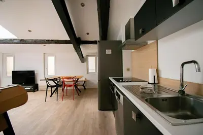 a kitchen with a sink and a table with chairs at Moderne et lumineux - clim - wifi in Aix-en-Provence