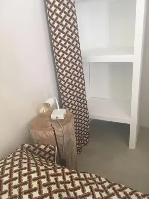 a bedroom with a bed and a table and a curtain at Luberon : maison près de Joucas et Gordes in Joucas