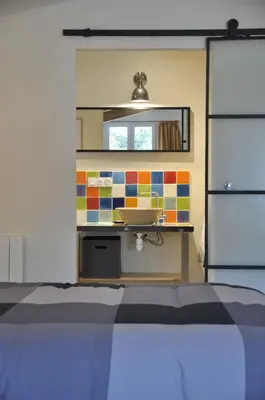 a bedroom with a sink and a mirror at Gite Hardy in Velleron