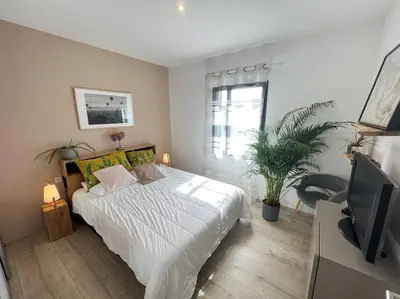 a bedroom with a white bed and a tv at 3 bedrooms new house with heated swimming pool in Carpentras