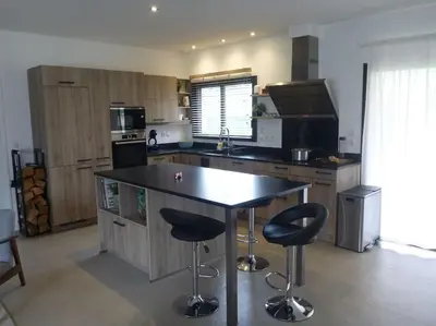 a kitchen with a large island with two bar stools at 3 bedrooms new house with heated swimming pool in Carpentras