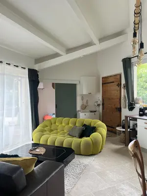 a living room with a yellow couch in the middle at Le p’tit bonheur-Piscine chauffée-clim-Park in Carpentras