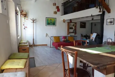 a living room with a table and a couch at Au Bregnat Vue du mont Ventoux in Bédoin