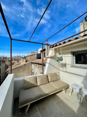 a couch sitting on the balcony of a building at Magnifique appartement + terrasse au cœur d’Aix in Aix-en-Provence