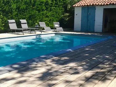 a swimming pool with chairs and a house at Joli gite en Provence avec piscine in Aubignan