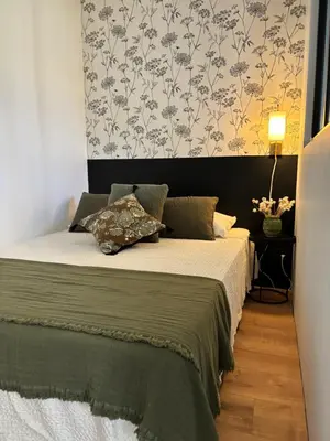 a bedroom with a bed with a wall with floral wallpaper at Joli gite en Provence avec piscine in Aubignan