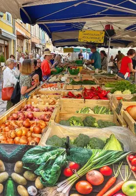 a market with many boxes of fruits and vegetables at Le Petit Delphia in Apt