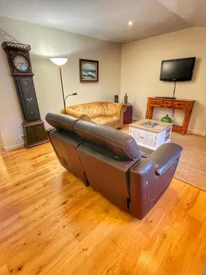 a living room with a couch and a clock at Le Petit Delphia in Apt