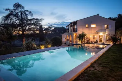 a large swimming pool in front of a house at Slpendid villa with heated pool and Jacuzzi for 12 people in Saint-chamas in Saint-Chamas