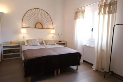 a bedroom with a bed with a mirror and a window at Slpendid villa with heated pool and Jacuzzi for 12 people in Saint-chamas in Saint-Chamas