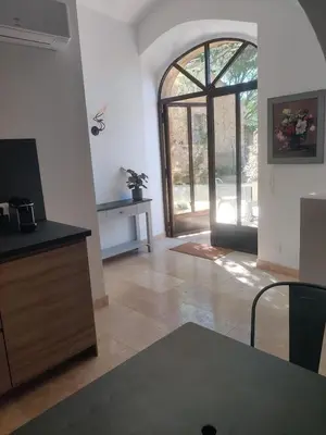 a living room with an open door to a patio at Charme et authenticité dans une ferme. in Lourmarin