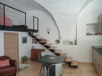 a spiral staircase in a room with a table and chairs at Charme et authenticité dans une ferme. in Lourmarin