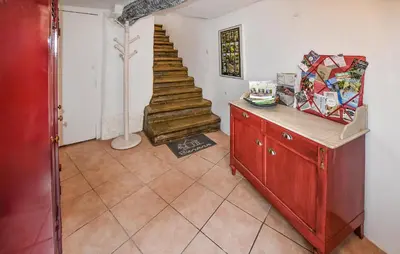 a living room with a staircase and a red dresser at Beautiful Home In L'isle-Sur-La-Sorgue in LʼIsle-sur-la-Sorgue