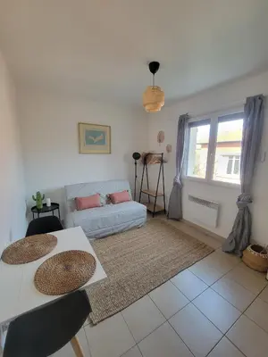 a living room with two tables and a couch at Joli studio lumineux centre avec parking securise dans quartier recherche in Aix-en-Provence