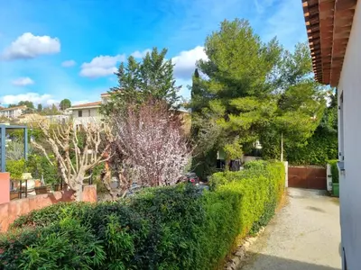 a garden with bushes and trees in front of a house at Joli studio lumineux centre avec parking securise dans quartier recherche in Aix-en-Provence