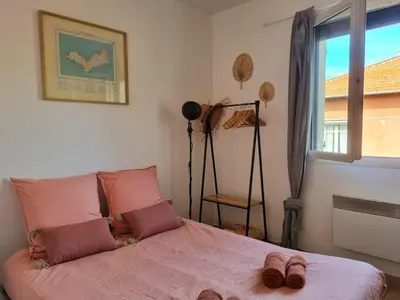 a bedroom with a bed with pink sheets and a window at Joli studio lumineux centre avec parking securise dans quartier recherche in Aix-en-Provence
