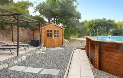 a backyard with a wooden cabin and a swimming pool at Nice Home In La-Roque-Sur-Pernes in La Roque-sur-Pernes