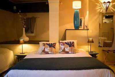 a bedroom with a large bed with two pillows at In Provence Hôtel - Expérience Authentique in Venelles