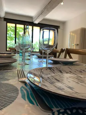 a table with plates and wine glasses on it at Le Mas de Bonnety - Magnifique mas 12 personnes au Pied du Mont Ventoux in Saint-Pierre-de-Vassols