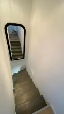 a mirror on a wall next to a staircase at la chambrette in Lincel