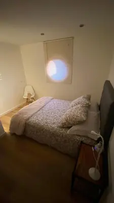 a bedroom with a bed and a small window at la chambrette in Lincel