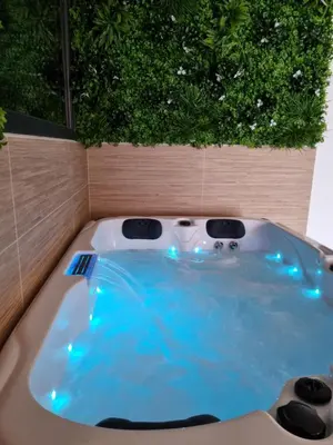 a jacuzzi tub with blue lights in a garden at Le Cocoon - Jacuzzi, Sauna et Piscine privée in Carpentras