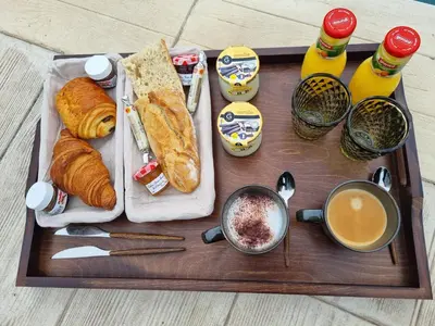 a tray with bread and pastries and a cup of coffee at Le Cocoon - Jacuzzi, Sauna et Piscine privée in Carpentras