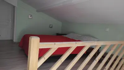 a bedroom with a bed with a red blanket at Location au cœur du Luberon 2 personnes in Saint-Saturnin-les-Apt