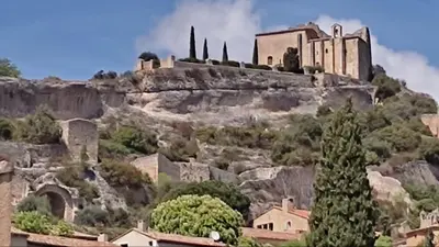 a monastery on top of a mountain with houses at Location au cœur du Luberon 2 personnes in Saint-Saturnin-les-Apt