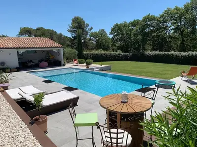 a swimming pool with a table and chairs next to it at Magnifique villa avec piscine Mt Ventoux Provence in Carpentras