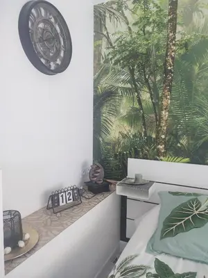 a bedroom with a bed and a clock on the wall at Studio Zen Miramas in Miramas