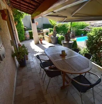 a patio with a table and chairs and a pool at Villa le 62 Cazan in Vernègues
