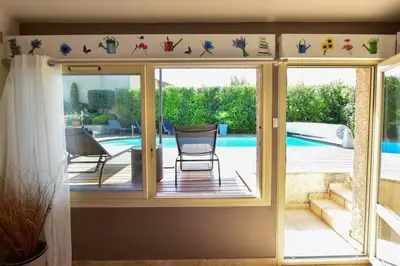 a room with a sliding glass door with a view of a pool at Villa le 62 Cazan in Vernègues
