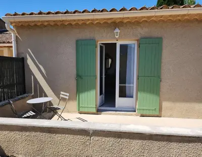 a green door with a table and a chair on a building at Le Clos Renaissance in Oppède